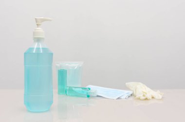 Coronavirus Önleme Ekipmanı, Tıbbi Maske El dezenfektanı ve tıbbi eldivenler beyaz masada. Diğerlerine hastalığın yayılmasını önlemek için bir kampanya mesajı eklemek için boş alan..