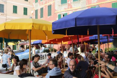 Renkli güneş şemsiyeleri altında Cafe'de oturan turistler, Vernazza, Cinque Terre, Liguria, İtalya
