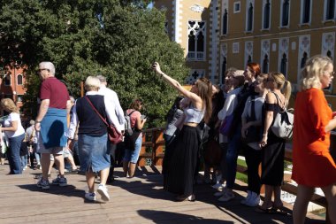 Bir grup turist kız bir anıtın önünde selfie yapıyor.