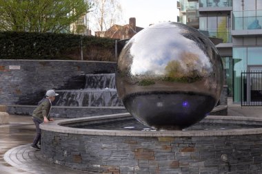 Bir çocuk playione Çocuk Woodberry park ve rezervuar gölünde mimar Murdoch Wickham tarafından küresel çeşme ile su çeşmesi üzerinde oynuyor