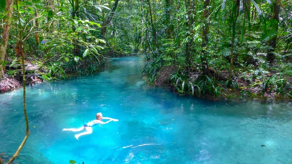 Girl swimming in the Kalibiru river, Hidden Blue River in Mayalibit, Waigeo, Raja Ampat, West Papua, Indonesia