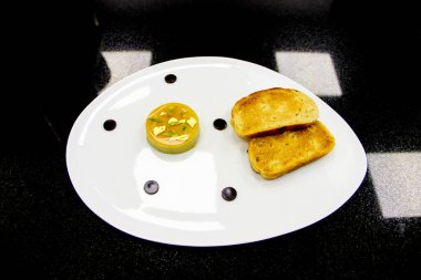 Balzamik sirkeyle ekşi mango jölesi ve izole edilmiş siyah arka planlı 45 derecelik açıyla izole edilmiş seramik tabakta kızarmış ekmek.