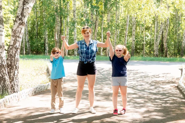 Happy mothe i jej dzieci robią kciuki w piękny słoneczny dzień. Aktywność na świeżym powietrzu z dziećmi. Letnia koncepcja aktywna — Zdjęcie stockowe