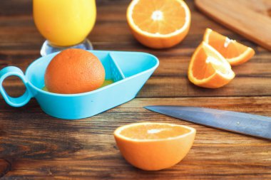 Ev mutfağında portakal suyu yapma süreci. Bir bardak taze meyve suyu. Sehpanın üzerinde otanjlar. Detoks, vejetaryen diyeti. Sulu, sağlıklı bir vitamin içeceği canlandırıcı bir meyve içeceğidir. meyve sıkacağı.