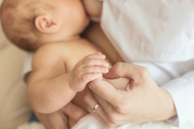 Anne yeni doğmuş çocuğunu emziriyor. Anne emziriyor ve besliyor..