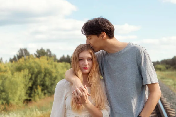 Chica rubia y chico pelo oscuro felizmente juntos en la naturaleza, historia de amor —  Fotos de Stock