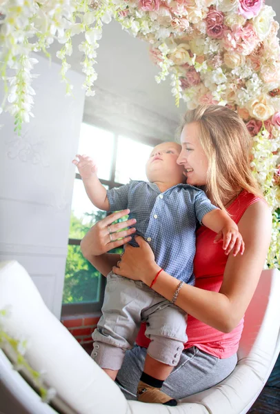 快乐的妇女母亲和婴孩在家玩花卉装饰 — 图库照片