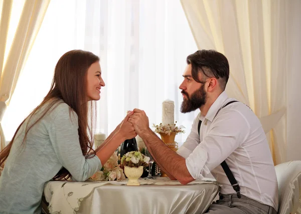 恋のテーブルで若いカップルを祝う手を繋いでいるロマンチックなディナー — ストック写真