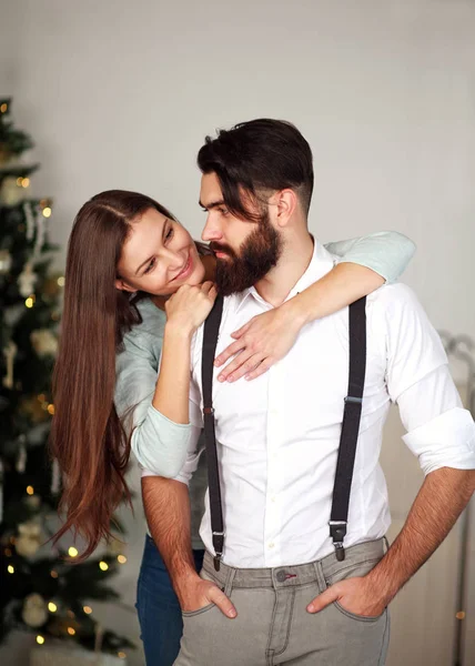 Mulher abraçando seu homem de negócios elegante em casa no Natal — Fotografia de Stock