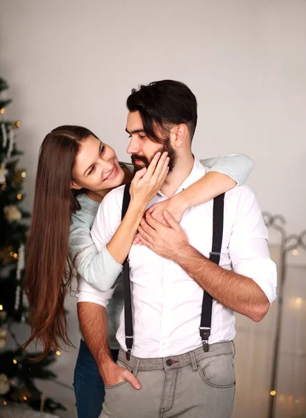 Mulher abraçando seu homem de negócios elegante em casa no Natal — Fotografia de Stock