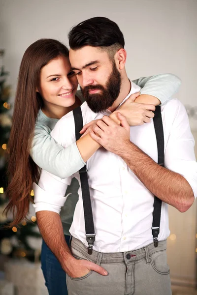 Mulher abraçando seu homem de negócios elegante em casa no Natal — Fotografia de Stock