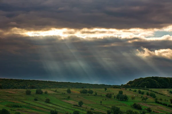 Raios Luz Sol Através Nuvens Cinzas Nos Campos Verdes Colina — Fotografia de Stock