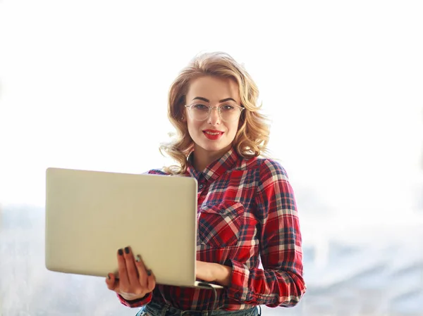 Jovem Atraente Óculos Fica Com Laptop Branco — Fotografia de Stock