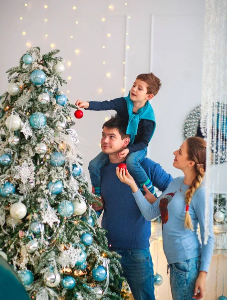 Happy friendly family decorating a Christmas tree have fun, father with his son on his shoulders