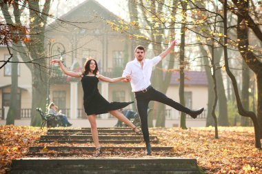 Erkek ve kadın tutkuyla günbatımında şehir parkında tango dans genç zarif çift