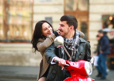 Mutlu genç çift bir turist şehirde bir scooter üzerinde aşık