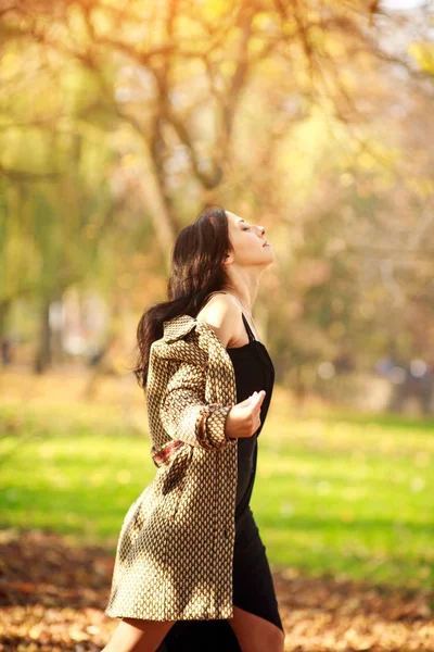 Dreamy girl enjoying the sun in the spring park, freshness of nature and freedom concept