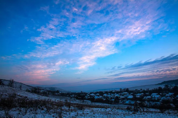 Colorful dawn sunrise in winter over hills and forests in the countryside village