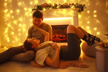 Mutlu genç çift şömine Noel tarafından evde aşık