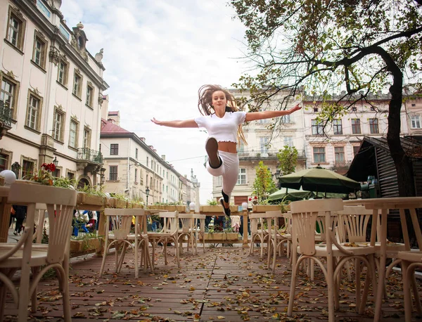 Sportowiec dziewczynka gimnastyczka skoki na ulicy Starego Miasta w okresie letnim — Zdjęcie stockowe