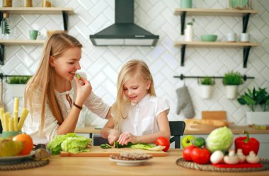 Anne ile kızı mutfakta taze sebze ile sağlıklı gıda hazırlama, ev yaşam tarzı ebeveynlik