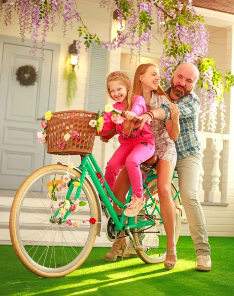 Šťastní rodiče s dítětem, dcerou, naučit se jezdit na kole — Stock fotografie