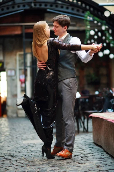 Joven pareja alegre en el amor bailando latino en la calle de la noche —  Fotos de Stock