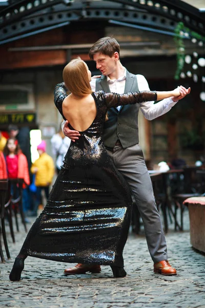 Joyful jovem casal apaixonado dançando latim na rua da noite — Fotografia de Stock