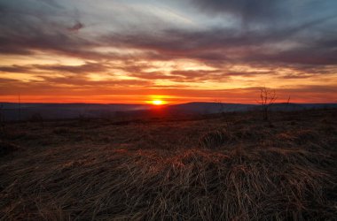 Tepeler ve alan üzerinde kırsal renkli muhteşem günbatımı