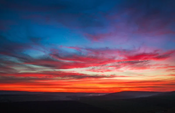 Színes pompás naplemente vidéken dombok felett és területen — Stock Fotó
