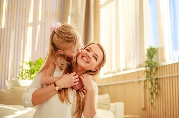 Anne ve kız sevinçle yatakta evde sarılmak — Stok fotoğraf