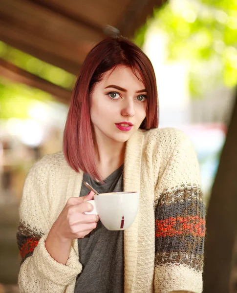 Stylish young woman on terrace of summer restaurant with cup — Stock Photo, Image