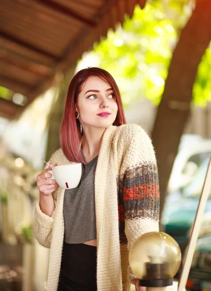 Stylish young woman on terrace of summer restaurant with cup — Stock Photo, Image