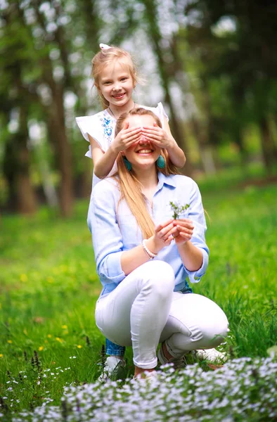母亲与女儿在绿茵盛开的夏季公园在草地上 — 图库照片