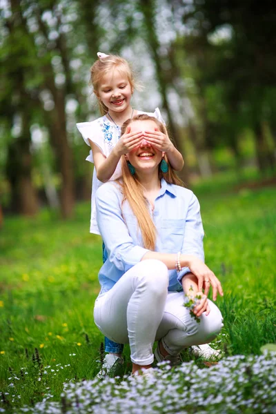 母亲与女儿在绿茵盛开的夏季公园在草地上 — 图库照片