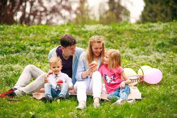 Çiçekli parkta piknik mutlu aile çim, ebeveyn üzerinde oturan Telifsiz Stok Fotoğraflar