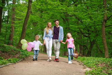 Yaz parkında yürüyen iki çocuklu aile babası ve annesi