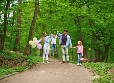 Yaz parkında yürüyen iki çocuklu aile babası ve annesi