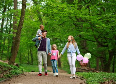 Yaz parkında yürüyen iki çocuklu aile babası ve annesi
