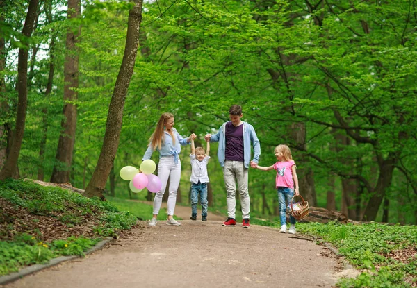 Padre de familia y madre con dos hijos caminando en el parque de verano — Foto de Stock