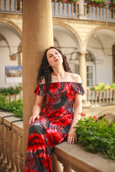 Молодая леди в длинном платье в европейском старом городе наслаждается солнцем — стоковое фото