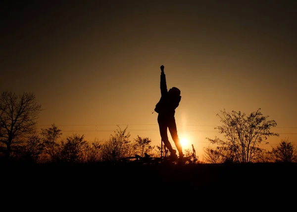 Silueta de niño con bicicleta sobre fondo de brillante puesta de sol — Foto de Stock