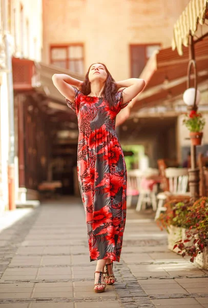Mujer pensativa en vestido largo y colorido en la calle del turista viejo —  Fotos de Stock