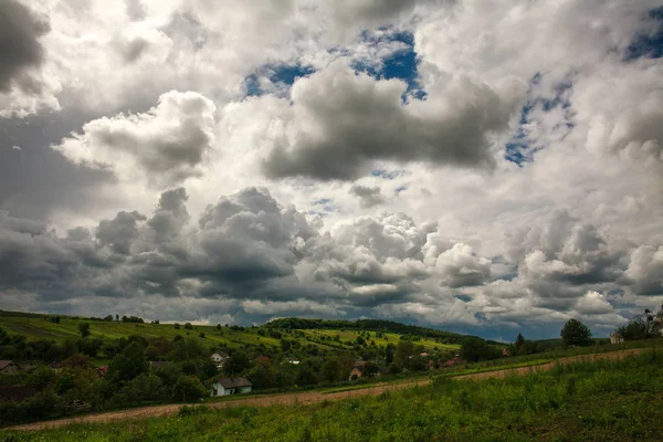Paisagem rural campos verdes em colinas no céu com nuvens — Fotografia de Stock
