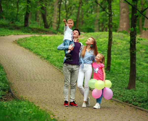 Счастливая молодая семья с двумя детьми гуляет летом Лицензионные Стоковые Фото