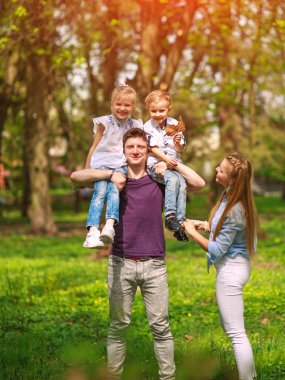 Çiçekli şehir parkında eğlenen aile portresi