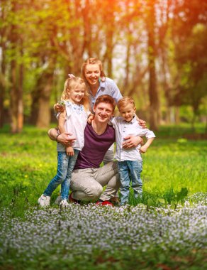 Çiçekli şehir parkında eğlenen aile portresi