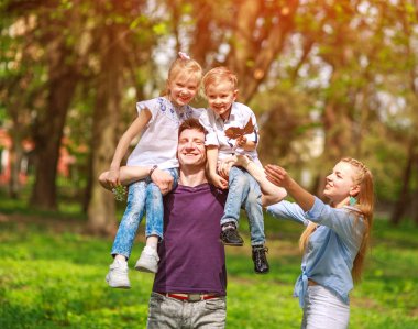 Çiçekli şehir parkında eğlenen aile portresi