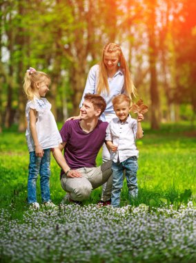 Çiçekli şehir parkında eğlenen aile portresi