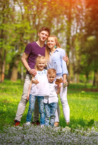 Çiçekli şehir parkında eğlenen aile portresi